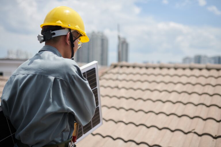 contractor-carrying-solar-panel-when-walking-roof (1)